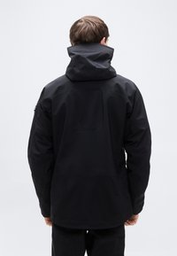 Μαύρο αδιάβροχο μπουφάν με ψηλό γιακά και κουκούλα. Διαθέτει λεία υφή και πλαϊνές τσέπες με φερμουάρ. Μινιμαλιστικός σχεδιασμός χωρίς ορατά λογότυπα.
