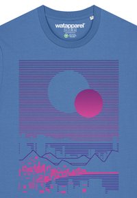 Blauwe katoenen T-shirt met een grafisch ontwerp van twee elkaar overlappende cirkels in blauw en roze, horizontale lijnen en een gestileerde stadsrand.