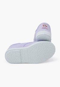 Purple canvas shoes with a textured white rubber sole. Features a patch on the heel with a monkey design. Made in Spain.