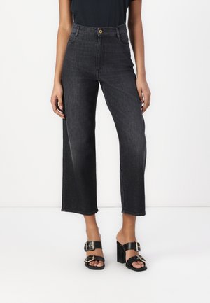 High-waisted black denim jeans with wide legs, contrasting stitching, side pockets, and a gold button closure at the waist.