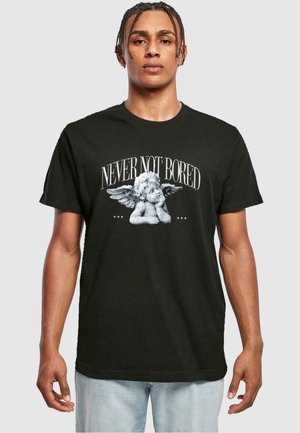 Sort bomulds t-shirt med et centralt grafisk motiv af en engel med en eftertænksom mine, tekst "ALDRIG IKKE KED AF DET" i fed hvid skrifttype.