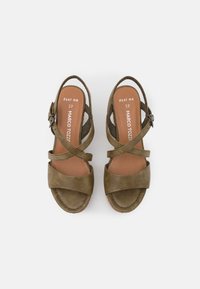 Olijfgroene sandalen van suede met een kruisbandontwerp, verstelbare gespen en een gewatteerde inlegzool. Platte zool met textuurdetails.