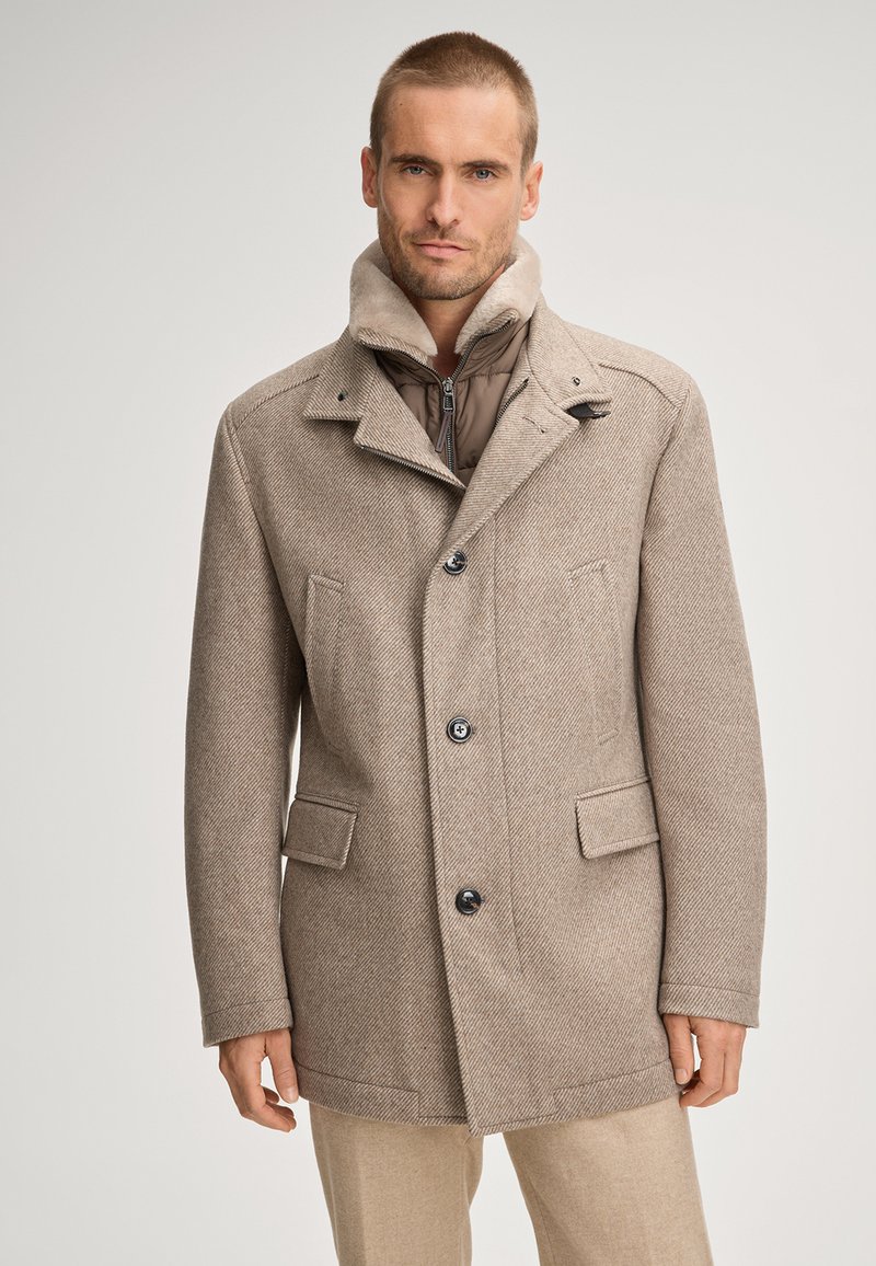 Beżowy płaszcz z mieszanki wełny z wzorem jodełki, z podwójnym zapięciem, dwoma przednimi kieszeniami i kołnierzem wyłożonym barankiem.