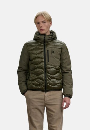 Olijfgroene pufferjack met een glanzende afwerking, gewatteerde textuur, rits aan de voorkant, verstelbare capuchon en een borstzak met branding.