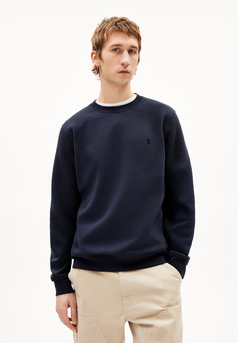 Marineblauwe sweatshirt met ronde hals, ribbels aan de mouwen en een klein geborduurd logo op de borst. Gemaakt van zachte, gestructureerde stof.