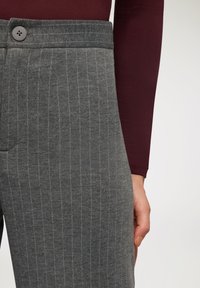 Szare spodnie w prążki o gładkiej fakturze, z zapięciem na guzik i dopasowanym kroju w talii.