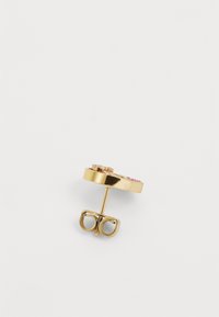 Guld cirkulär örhänge med en blommig design och rosa detaljer. Fästen inkluderar en stift och en fjärilslås för säker bärning.