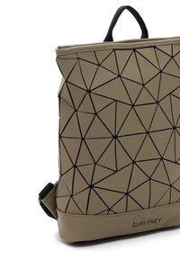 Sac à dos beige avec des lignes géométriques noires formant des triangles, une poignée supérieure noire et le logo "SURI FREY" en bas à l'avant.