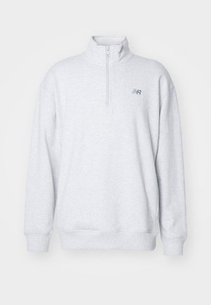 Grå zip-up sweatshirt lavet af blødt stof, med høj krave og lange ærmer. Lille logo-tryk på brystet. Simpelt design.