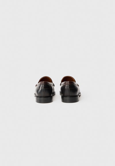 Svarta läder loafers med en slät yta, med rundad tå och liten klack. Diskreta sömnadsdetaljer på baksidan och sidorna.