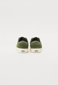 Grønne semskede sneakers med hvide gummisåler, med broderede detaljer, nummereringsdetalje "66/99" og Vans-logo på hælen.