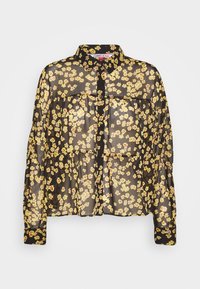 Blusa nera trasparente con motivo floreale giallo e rosso, maniche lunghe, chiusura con bottoni davanti e due tasche sul petto. Tessuto leggero e texturizzato.