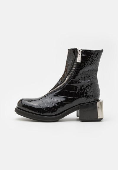 Schwarze Lackleder-Ankle-Boots mit Krokodilprägung, geschwungenem Zehenbereich, seitlichem Reißverschluss und quadratischem metallischen Absatz.