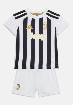 Stroje piłkarskie Juventusu z czarno-białymi pionowymi paskami na koszulce, złotymi logo oraz białe spodenki z złotym emblematem Juventusu.
