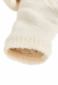 Kreemivärviline fliissvöönd, millel on tekstureeritud välimus ja pehme, karvane siseosa. Pööratud serv lisab soojust ja mugavust.