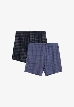 Dwie pary męskich bokserek w kratę, jedna czarna z niebieskimi liniami, a druga niebieska z czerwonymi liniami, obie z rozporkiem na guziki i elastycznymi pasami w talii.