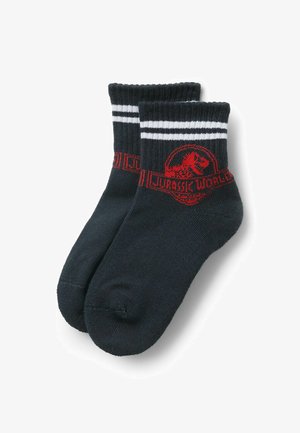 Schwarze Socken mit weißen Streifen am oberen Rand, versehen mit einem roten Jurassic World-Logo und einem Dinosaurier-Graphic auf dem Bund.