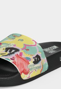 Μαύρο σανδάλι slide με πολύχρωμα λουλουδάτα και αφηρημένα σχέδια στο λουράκι, με την ονομασία "Love Moschino" σε γραφικό και εκτυπωμένο γράμμα.