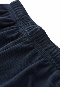 Schwarze atmungsaktive Sportshorts aus Mesh mit einem elastischen Bund, versehen mit einem strukturierten Material und gerafften Details entlang des Bunds.