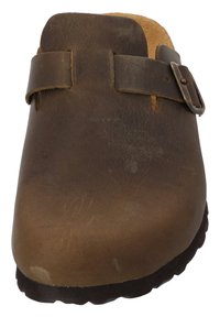 Bruine leren klomp met minimaal design, voorzien van een dubbele band met een metalen gesp. De zool is gestructureerd en donker voor betere grip.