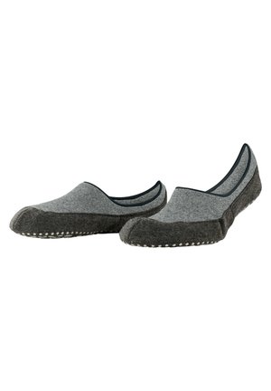 Zapatillas grises sin cordones con una parte superior de tela suave, acentos en un gris más oscuro y detalles de puntos blancos en la suela. Sin cordones ni cierres visibles.