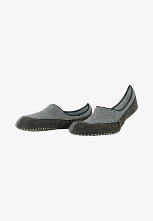 Zapatillas grises sin cordones con una parte superior de tela suave, acentos en un gris más oscuro y detalles de puntos blancos en la suela. Sin cordones ni cierres visibles.
