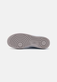 Nike sporta apavu zole gaiski pelēkā krāsā ar apļveida rakstiem un teksturētu virsmu; iekļauj izcilas akcentus un zīmola logo centrā.