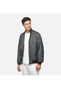 Giacca bomber grigia leggera con chiusura a zip, polsini elastici e dettagli arancioni. Caratterizzata da due tasche laterali e colletto alto.