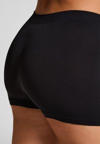 Schwarze Sportshorts mit glatter Textur, ausgestattet mit einem breiten Bund und einem figurbetonten Design, das sich an den Körper anschmiegt.