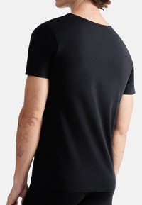 Black short-sleeve t-shirt with a smooth cotton texture, featuring a round neckline and a regular fit, seen from the back.