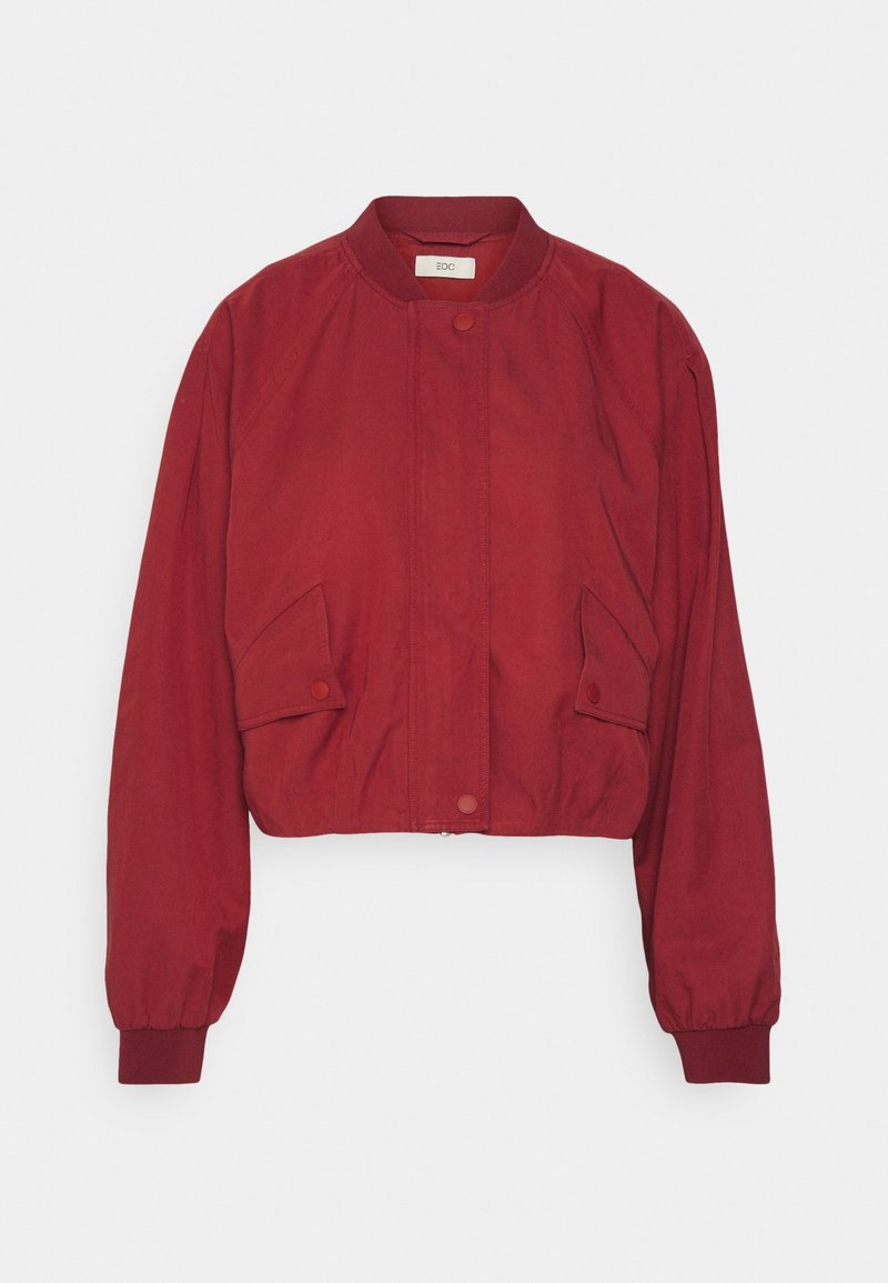 Veste bomber rouge raccourcie avec un col rond, boutons-pression, poches latérales et poignets élastiques. Fabriquée en tissu lisse et léger.