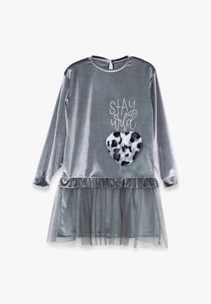 Grå fløjls kjole med lange ærmer, lagdelt kant, gennemsigtig tyloverflade og en sort-hvid leopardprint hjerte applique. Teksten "STAY WILD" ovenover.