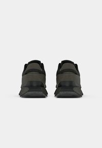 Black and gray sneakers with a mesh upper, reinforced heel, textured midsole, and rubber outsole. Features subtle branding on the back.