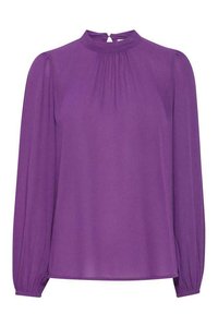 Blusa lunga viola con maniche lunghe, colletto alto, davanti plissettato e polsini arricciati. Realizzata in un tessuto leggero e liscio.