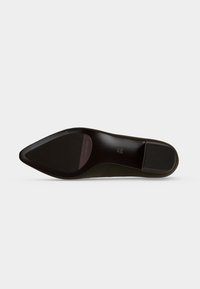 Semelle d'une chaussure plate noire à bout pointu indiquant la taille 4½ 37½ et la marque "THIRY RASER" sur un fond clair uni.