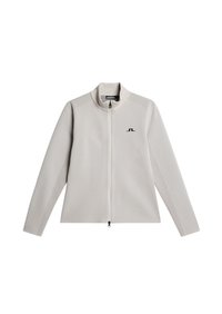 Veste zippée gris clair avec un col haut, des accents texturés sur les épaules et un petit logo sur la poitrine ; présente un détail en mesh sur les manches.