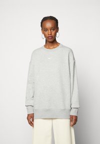 Gray sweatshirt with a crew neckline and relaxed fit. Features a small white Nike logo on the chest and ribbed cuffs and hem.