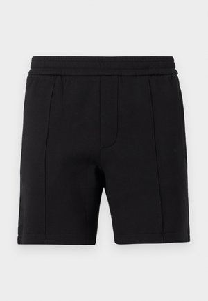 Svarte shorts til knelengde med elastisk midjebånd og vertikal sømdetalj på forsiden.