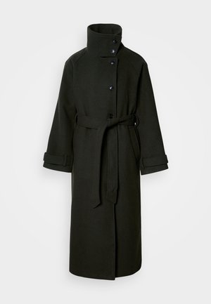 Casaco preto longo feito de tecido texturizado, apresentando um colarinho alto, fecho de botão e um cinto removível na cintura. Detalhe de punhos dobrados.