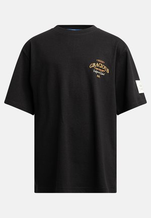 T-shirt en coton noir à manches courtes, col rond et broderie jaune sur le devant. Comprend un détail de label sur le côté.