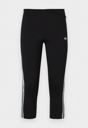 Fekete rövidített leggings fehér három csíkos oldalpanelekkel és kis Adidas trefoil logóval a bal combon.