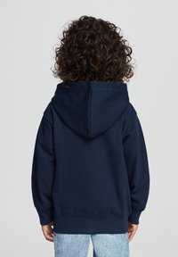 Felpa con cappuccio blu navy dal tatto morbido, con polsini e orlo a costine. Presenta un grande cappuccio e una vestibilità ampia. Vista posteriore mostrata.