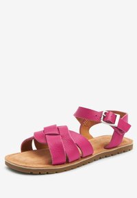 Sandalo in pelle fucsia con cinturini incrociati, fibbia alla caviglia regolabile, soletta marrone morbida e suola in gomma testurizzata per una migliore aderenza.