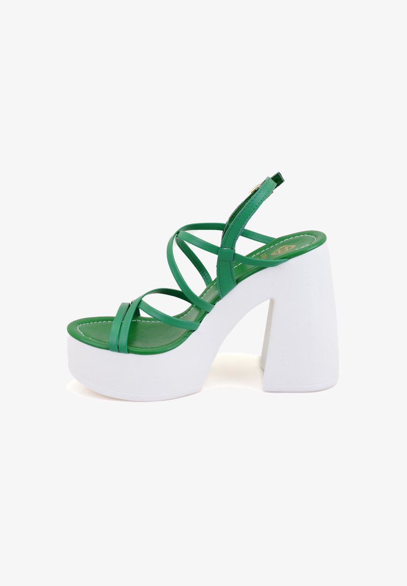 Sandale plateforme verte avec un épais talon blanc, plusieurs sangles entrecroisées et une finition synthétique lisse avec une semelle rembourrée.