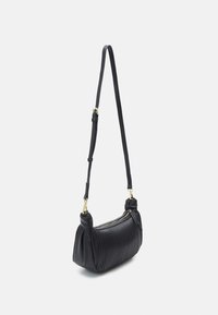 Černá kožená kabelka přes rameno s vroubkovanou texturou, zlatými kovovými prvky a nastavitelným popruhem. Zipové zapínání na horní straně.