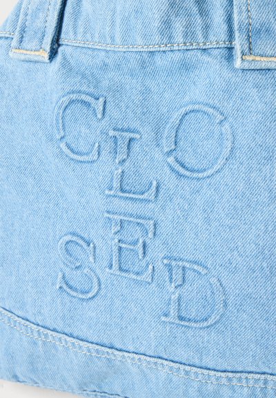 Tissu en denim bleu clair avec des lettres en relief formant le mot « CLOSED » cousues dans un motif croisé vertical et horizontal.