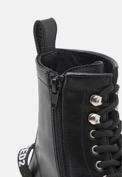 Črne usnjene gležnjarje z bočnim zadrgo, vezalkami spredaj, kovinskimi obroči in zanko za enostavno obuvanje.