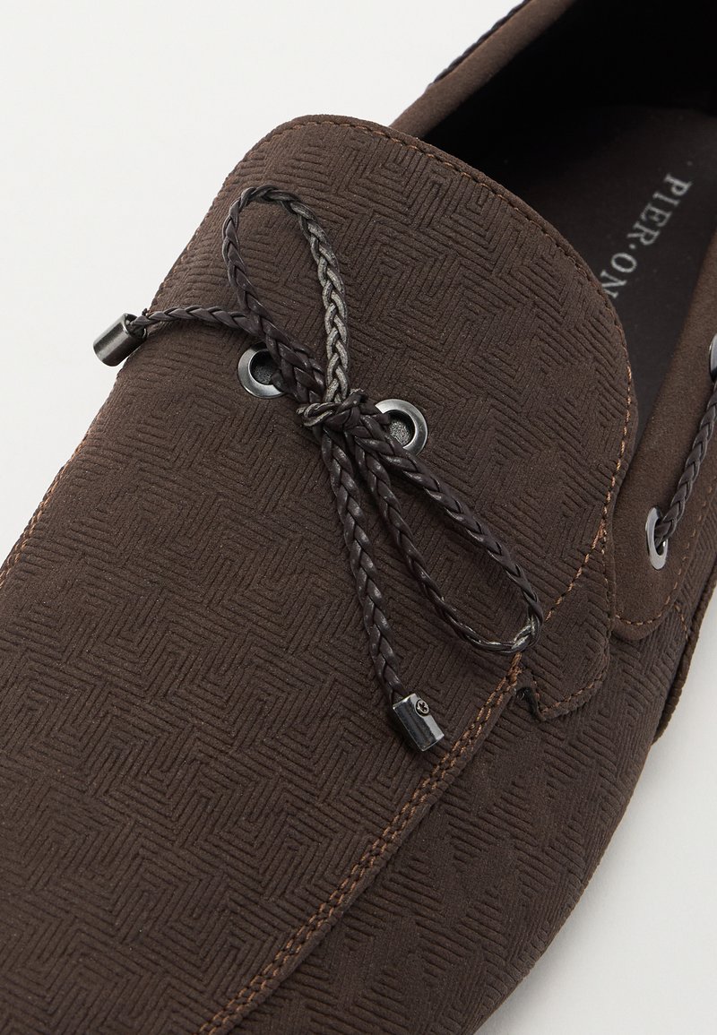 Zapato marrón texturizado con un patrón de espiga, con cordones trenzados grises, ojales de metal y costura en contraste.