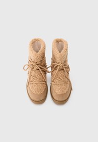 Tan ankle boots featuring soft, textured upper, suede accents, and rounded toes with a lace-up design.