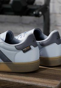 Lichtblauwe sneakers met grijze accenten. Voorzien van een geperforeerde textuur, rubberen zool en een CORDURA-label. Ronde neus en laag model.